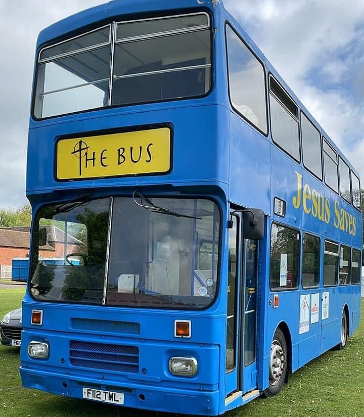 Photo of a blue double decker bus with a yellow sign 'The Bus' on the front